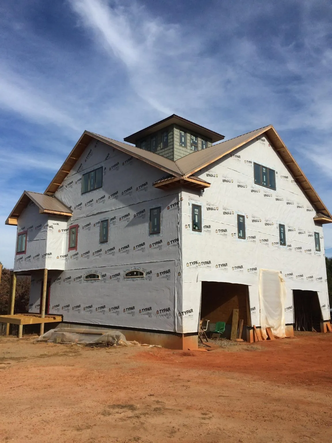 New two story house under construction with a cupola and gabled roofs in New Boston